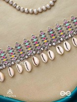 SHANKHAMALA-CONCH GARLAND- OXIDIZED NECKPIECE FEATURING PASTEL-COLOURED METALWORK, EMBELLISHED WITH DANGLING COWRIE SHELLS AND GHUNGROO'S