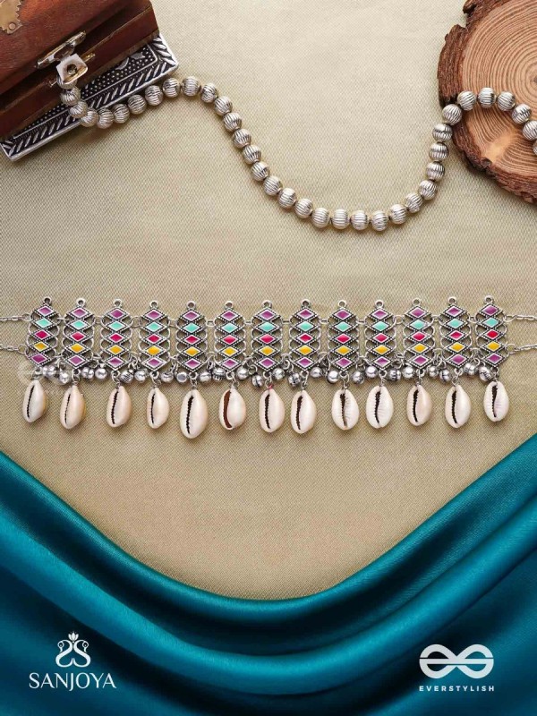 SHANKHAMALA-CONCH GARLAND- OXIDIZED NECKPIECE FEATURING PASTEL-COLOURED METALWORK, EMBELLISHED WITH DANGLING COWRIE SHELLS AND GHUNGROO'S