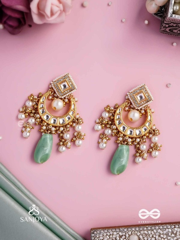 PURNIMA PHOOL – FULL MOON FLOWER AN EXQUISITE KUNDAN EARRING FEATURING GOLDEN DESIGNS, PEARL CLUSTERS, AND A GREEN GEMSTONE DROP, SYMBOLIZING ELEGANCE