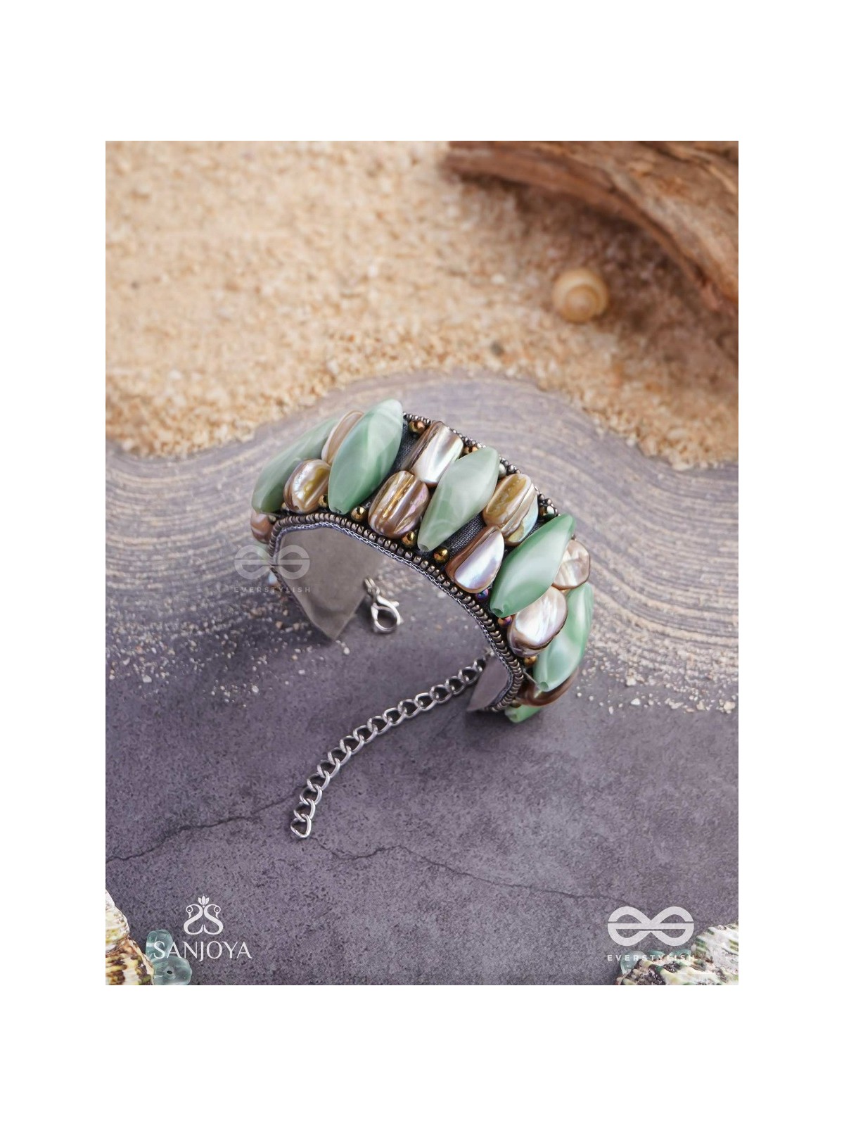 Shuktimālā- Shell band-Expandable bracelet crafted from shell beads, combining turquoise and beige-brown tones with a brassy finish.