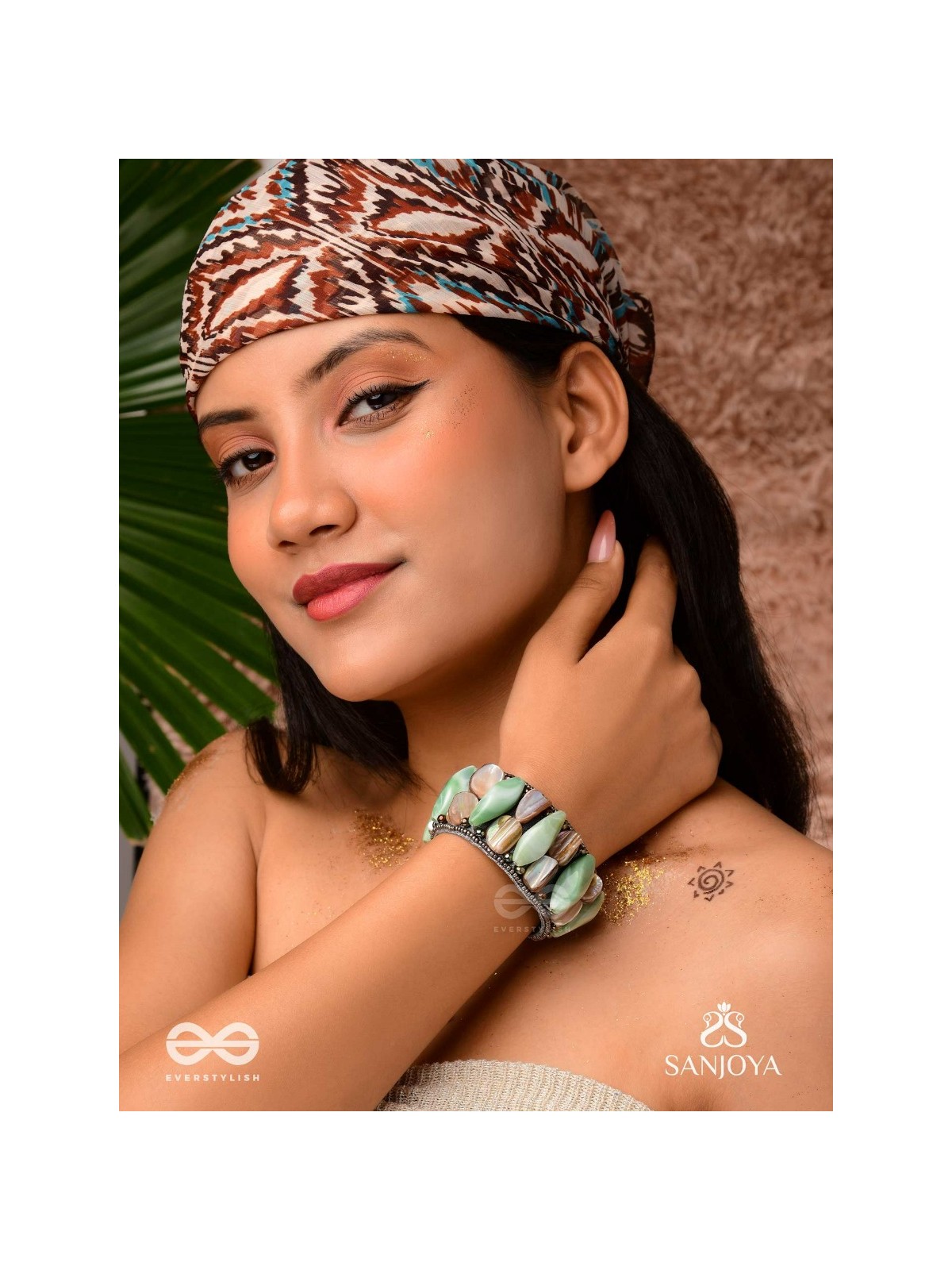 Shuktimālā- Shell band-Expandable bracelet crafted from shell beads, combining turquoise and beige-brown tones with a brassy finish.