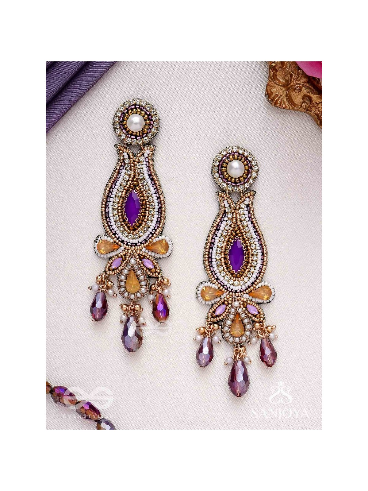 Divyaśhobhanā-Divine Splendour-Lotus-inspired embroidered design, adorned with purple and golden gem-studded motifs, Pearl and Beads.