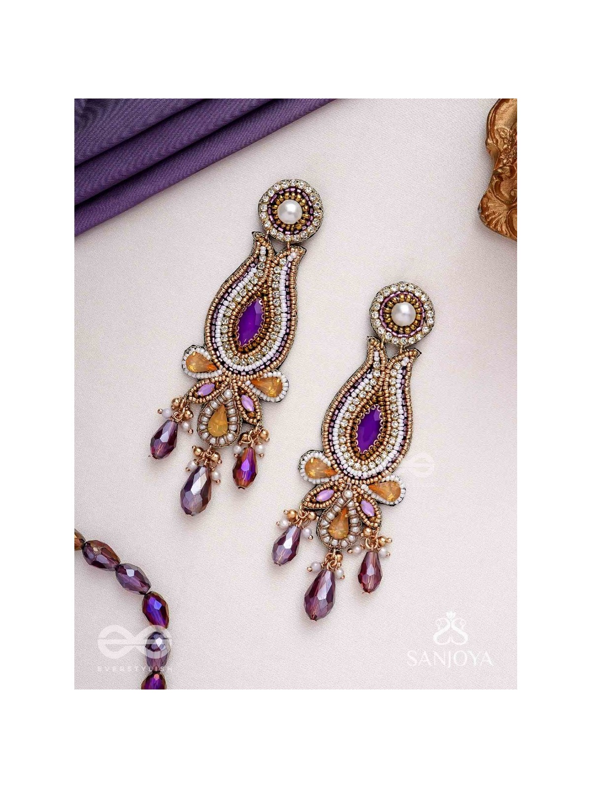 Divyaśhobhanā-Divine Splendour-Lotus-inspired embroidered design, adorned with purple and golden gem-studded motifs, Pearl and Beads.