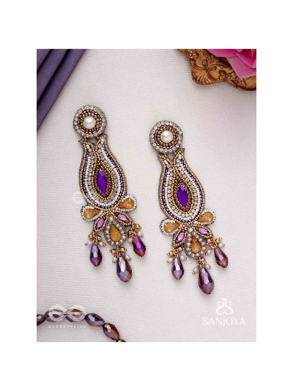 Divyaśhobhanā-Divine Splendour-Lotus-inspired embroidered design, adorned with purple and golden gem-studded motifs, Pearl and Beads.