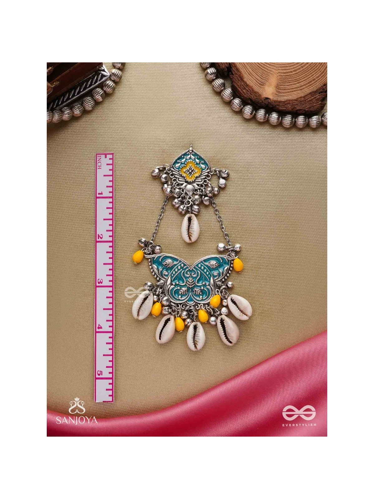 SHANKHA PUSHPA- CONCH BLOSSOM-OXIDIZED EARRINGS WITH PASTEL-HUED METALWORK, EMBELLISHED WITH DELICATE COWRIE SHELLS, YELLOW BEADS AND GHUNGROO