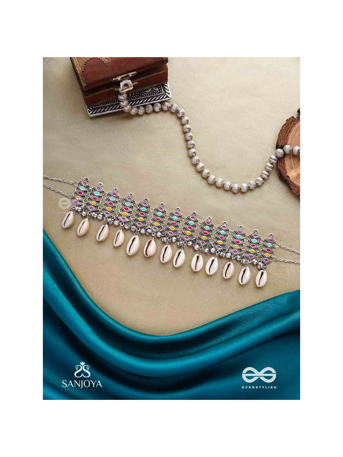 SHANKHAMALA-CONCH GARLAND- OXIDIZED NECKPIECE FEATURING PASTEL-COLOURED METALWORK, EMBELLISHED WITH DANGLING COWRIE SHELLS AND GHUNGROO'S