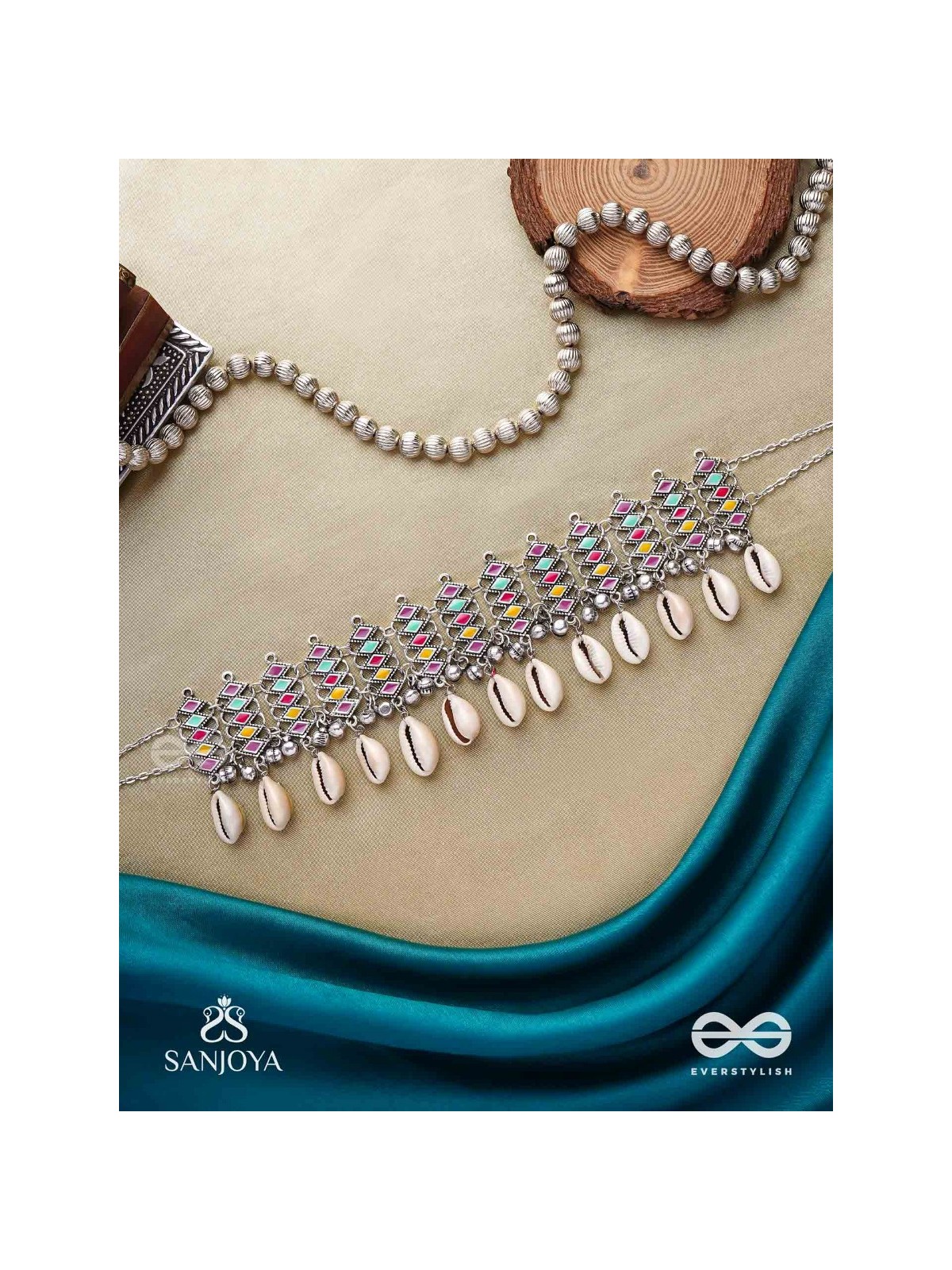 SHANKHAMALA-CONCH GARLAND- OXIDIZED NECKPIECE FEATURING PASTEL-COLOURED METALWORK, EMBELLISHED WITH DANGLING COWRIE SHELLS AND GHUNGROO'S