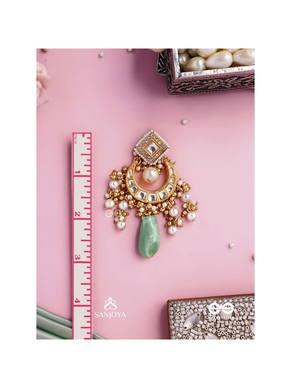 PURNIMA PHOOL – FULL MOON FLOWER AN EXQUISITE KUNDAN EARRING FEATURING GOLDEN DESIGNS, PEARL CLUSTERS, AND A GREEN GEMSTONE DROP, SYMBOLIZING ELEGANCE
