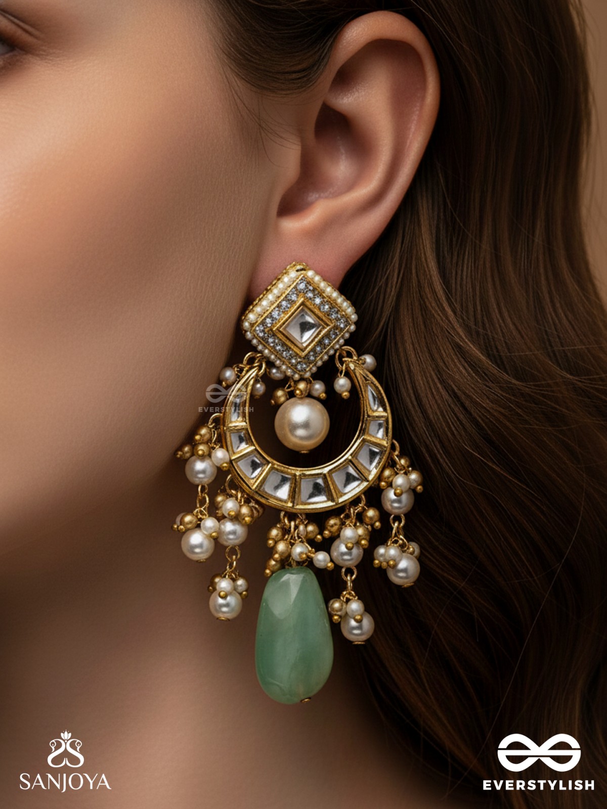 PURNIMA PHOOL – FULL MOON FLOWER AN EXQUISITE KUNDAN EARRING FEATURING GOLDEN DESIGNS, PEARL CLUSTERS, AND A GREEN GEMSTONE DROP, SYMBOLIZING ELEGANCE